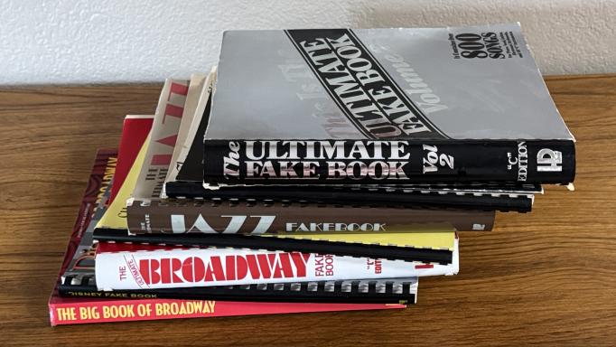 Pile of 7 thick books of sheet music encompassing several genres including jazz and broadway show tunes.